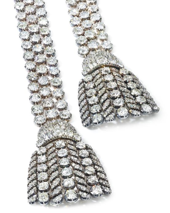 Колье выполнено в виде трех рядов бриллиантов, которые заканчиваются бриллиантовыми кисточками на обоих концах