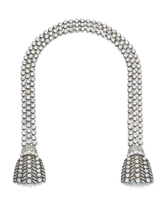 Колье выполнено в виде трех рядов бриллиантов, которые заканчиваются бриллиантовыми кисточками на обоих концах