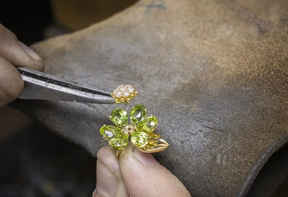 Лепестки из камней приподняты над оправой, а бриллиантовая сердцевина – над лепестками