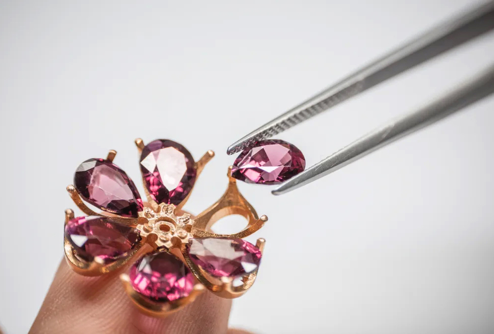 Лепестки из камней приподняты над оправой, а бриллиантовая сердцевина – над лепестками